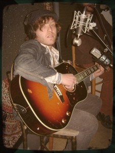 Greg Gilmore of The Kanes looking sedated while holding a guitar.